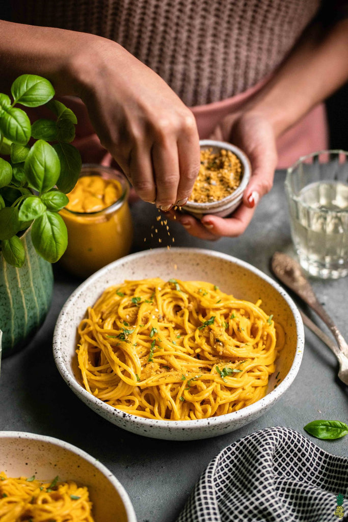 A creamy kabocha squash and red pepper pasta sauce that is made by blending together a mix of vegetables, cashews, spices and broth